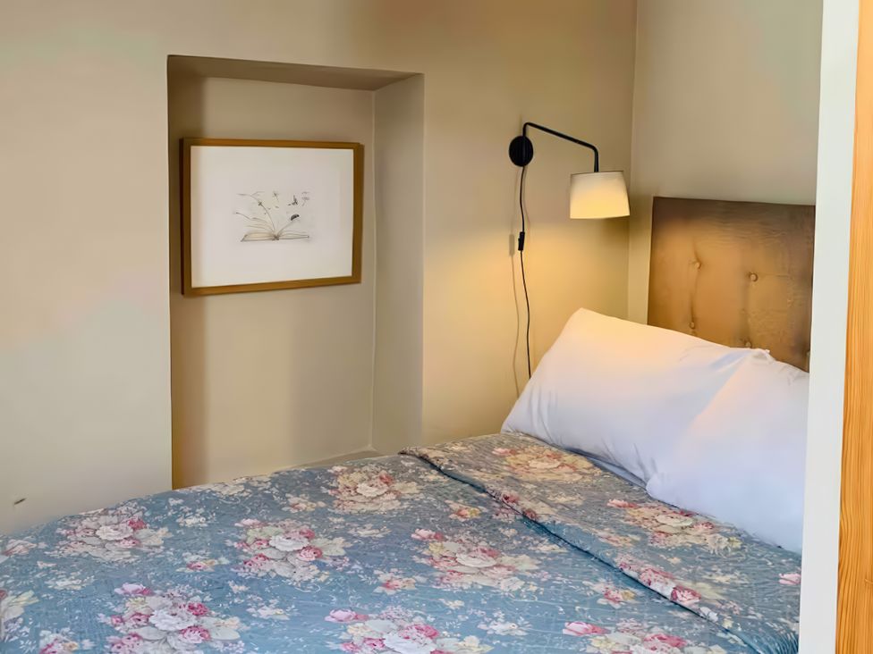 A bedroom with a bed and wall art at Copper Miners Cottage, Beddgelert, Eryri (snowdonia)