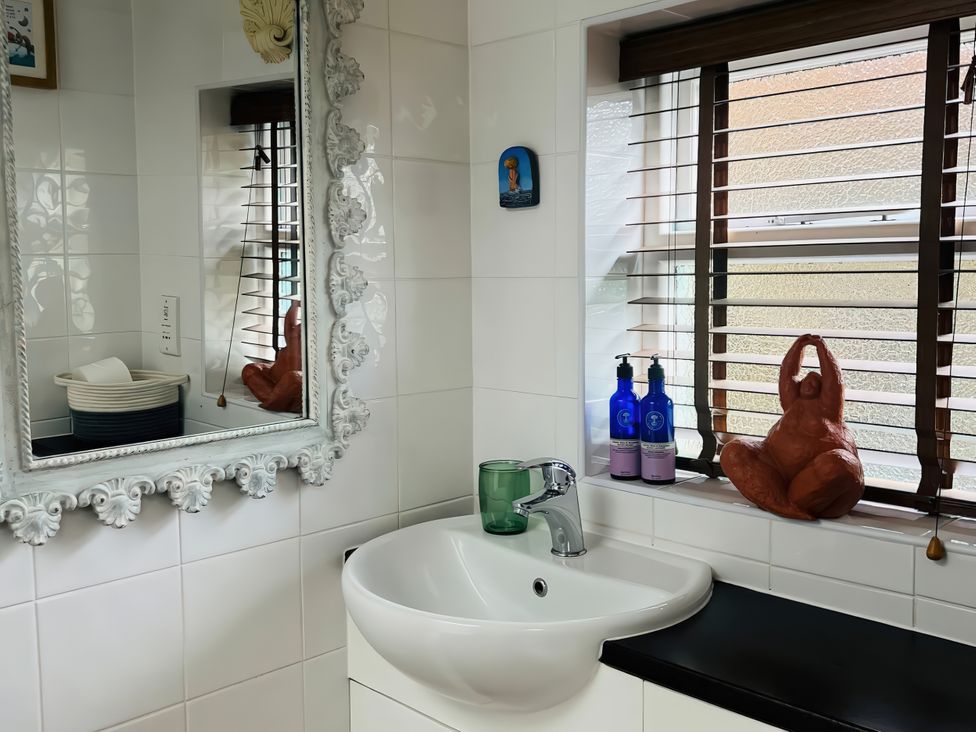 A bathroom with a sink and a mirror at Copper Miners Cottage, Beddgelert, Eryri (snowdonia)