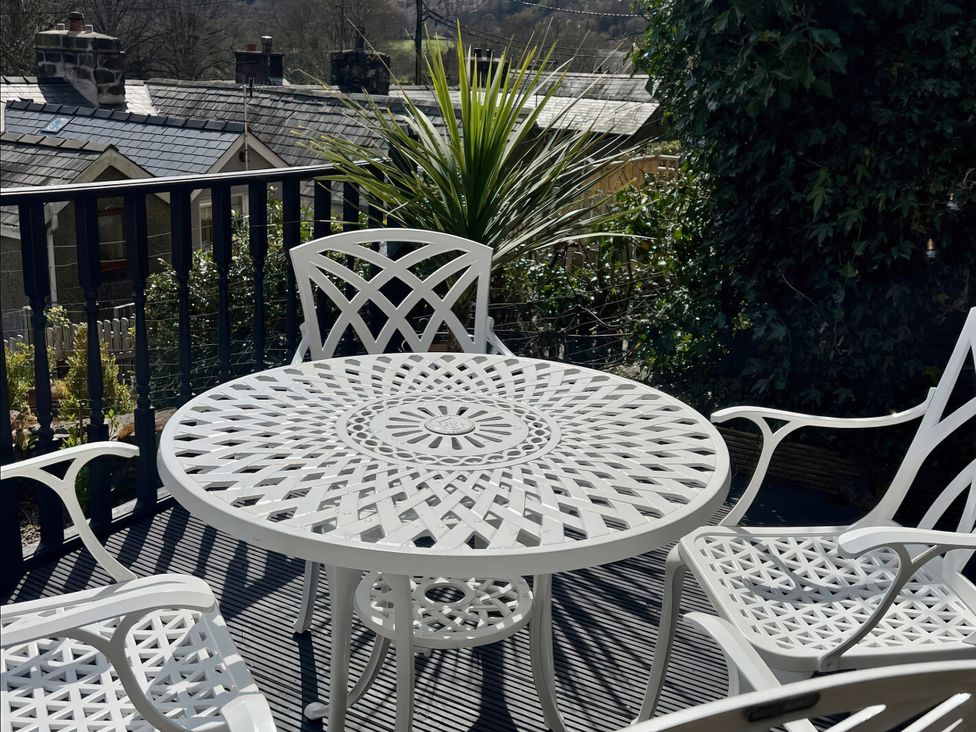 An outdoor seating area with a table and chairs at Copper Miners Cottage, Beddgelert, Eryri (snowdonia)
