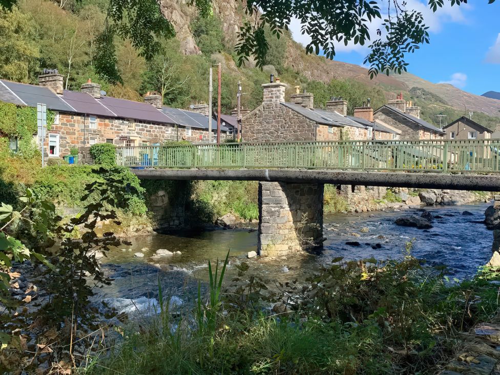 A view of houses and a bridge over a river at Copper Miners Cottage in Beddgelert, Eryri (snowdonia)