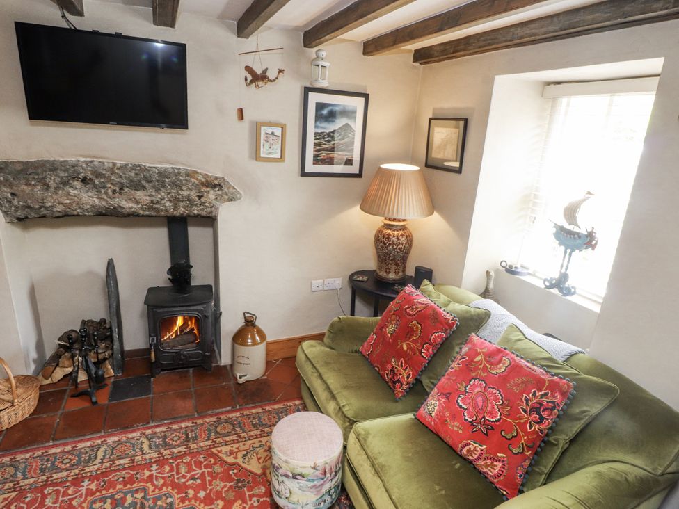 A living room with a fireplace and a sofa at Copper Miners Cottage in Beddgelert, Eryri (snowdonia)
