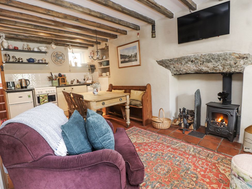 A living room with a sofa, table, and fireplace at Copper Miners Cottage, Beddgelert, Eryri (snowdonia)