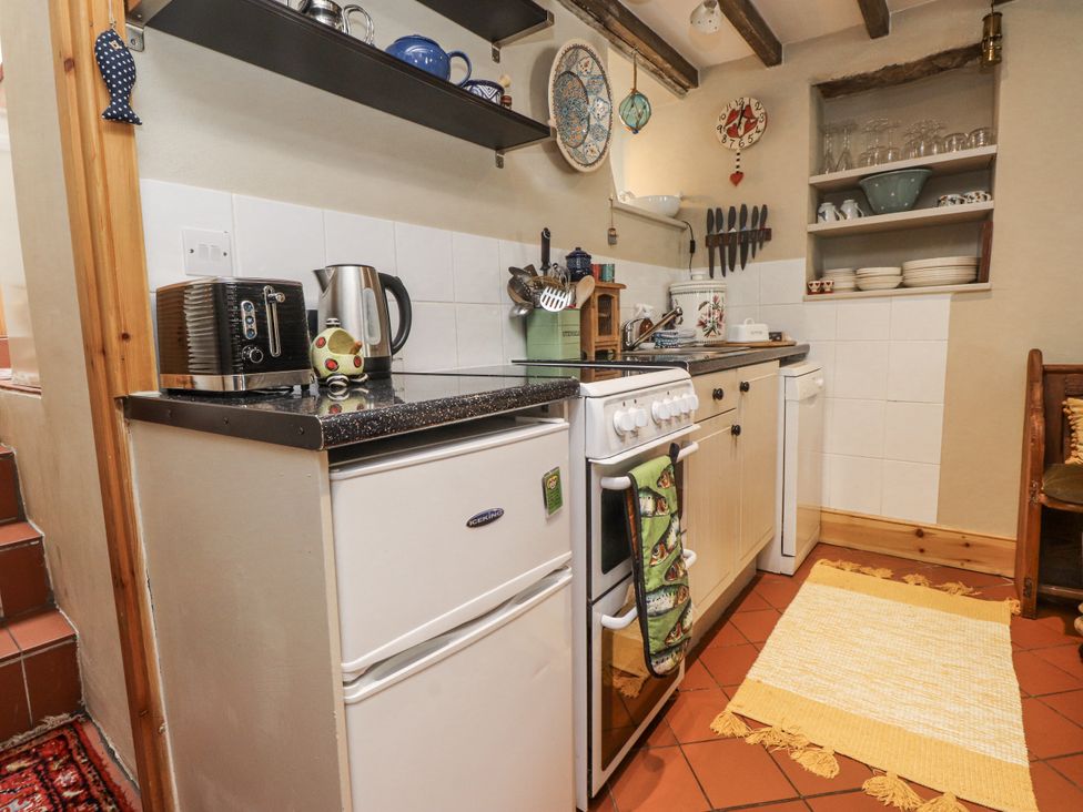 A kitchen with an oven, fridge, kettle, and utensils at Copper Miners Cottage in Beddgelert, Eryri (snowdonia)
