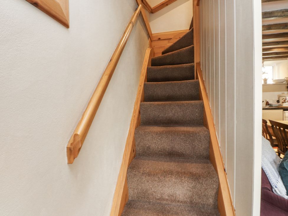 A staircase with carpet and a handrail at Copper Miners Cottage in Beddgelert, Eryri (snowdonia)