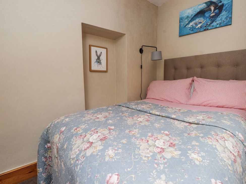 A bedroom with a bed and wall art at Copper Miners Cottage, Beddgelert, Eryri (snowdonia)