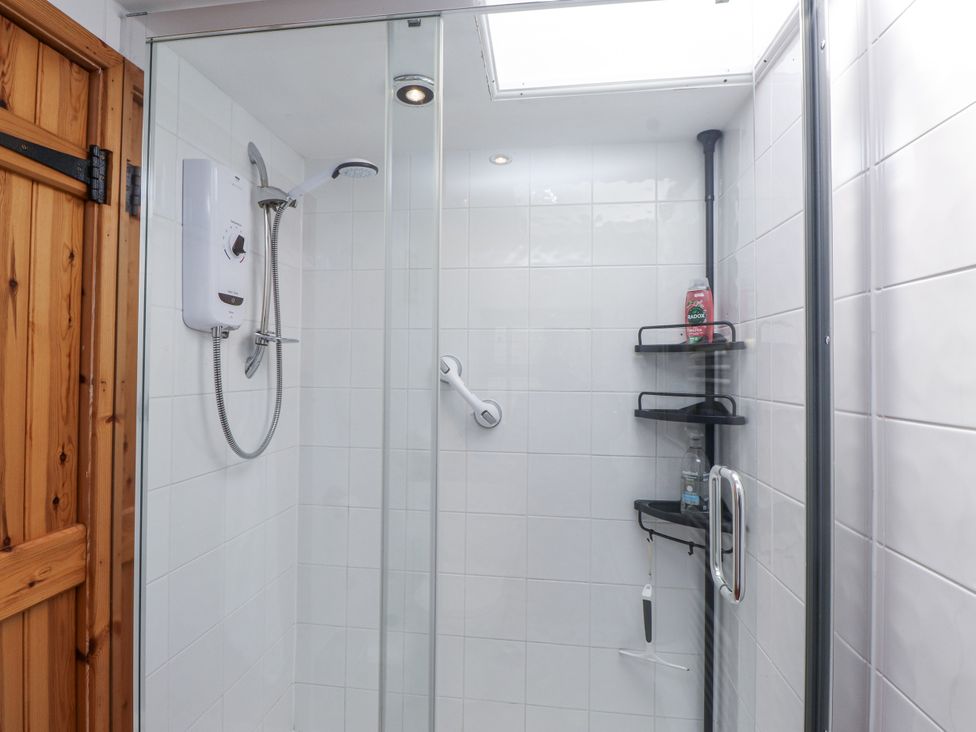 A shower with a control panel and shelves at Copper Miners Cottage Beddgelert, Eryri (snowdonia)