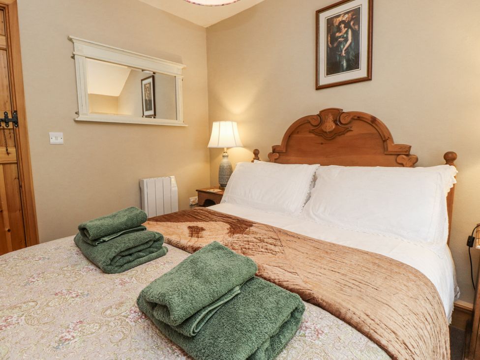 A bedroom with a bed and towels at Copper Miners Cottage Beddgelert, Eryri (snowdonia)