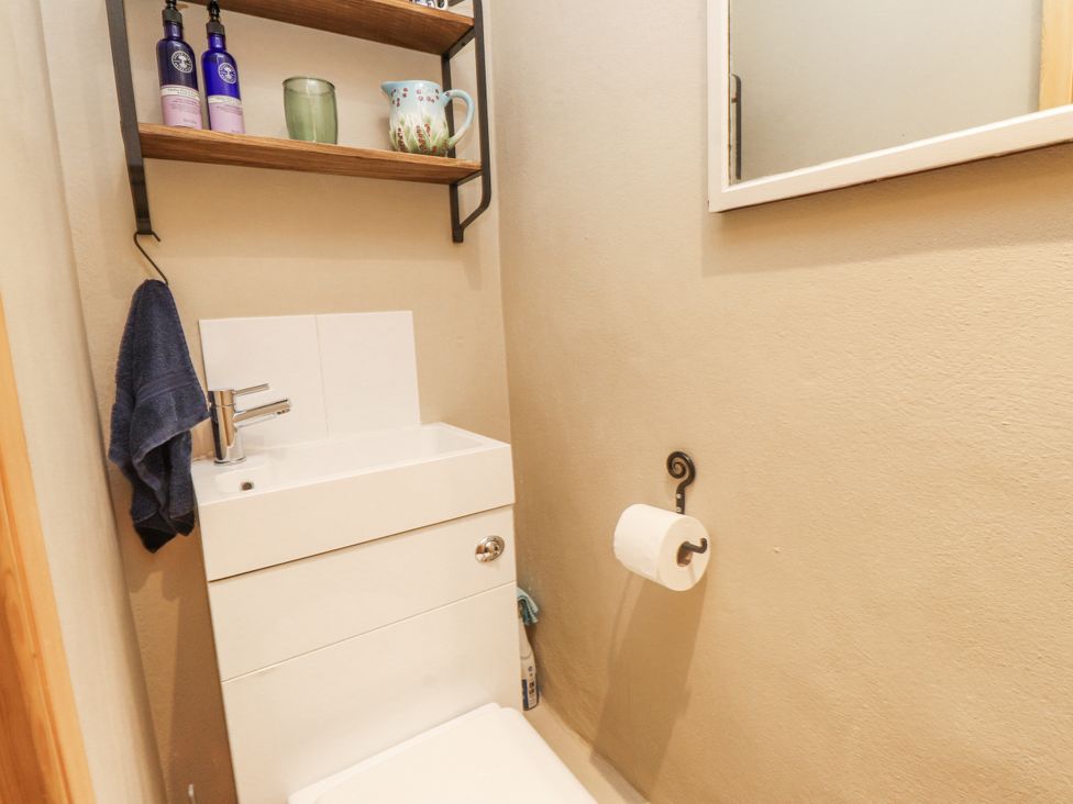 A bathroom with a sink and shelf at Copper Miners Cottage Beddgelert, Eryri (snowdonia)