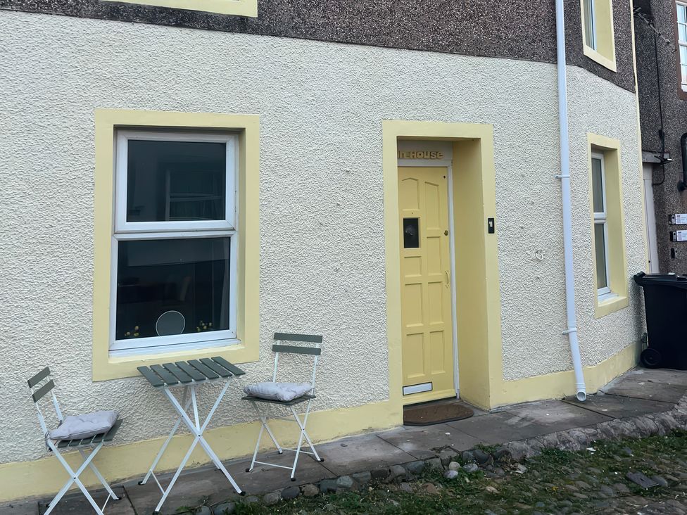 A doorway and window with outdoor seating at Sun House in Allonby
