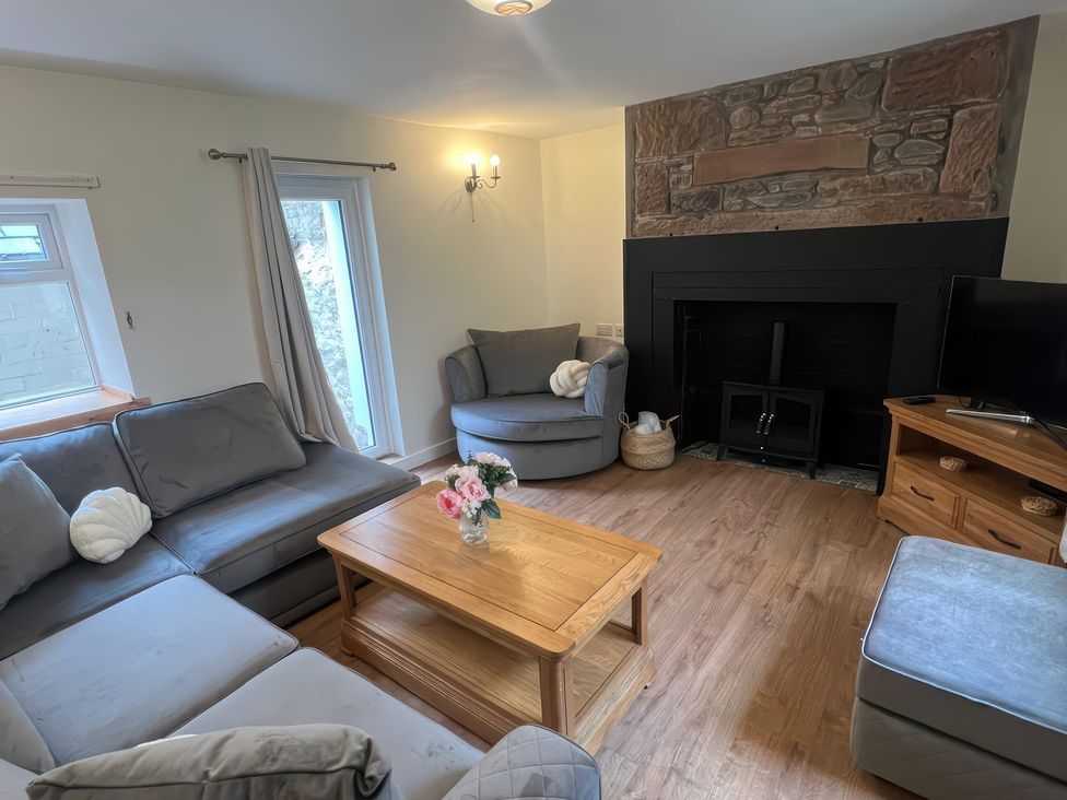 A living room with a sofa and coffee table at Sun House in Allonby