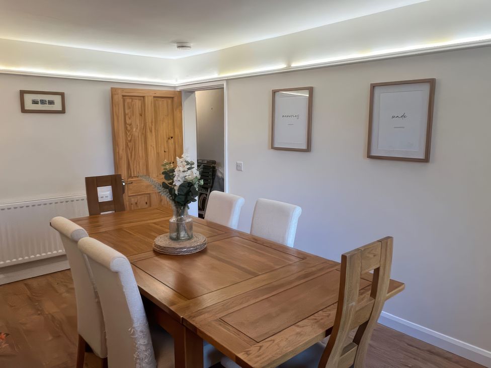 A dining room with a wooden table and chairs at Sun House in Allonby