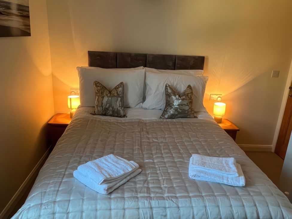 A bedroom with a bed and towels at Sun House in Allonby