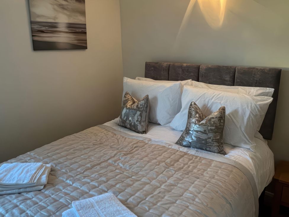 A bedroom with a bed and pillows at Sun House in Allonby