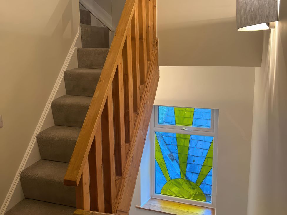 A staircase with a stained glass window at Sun House in Allonby