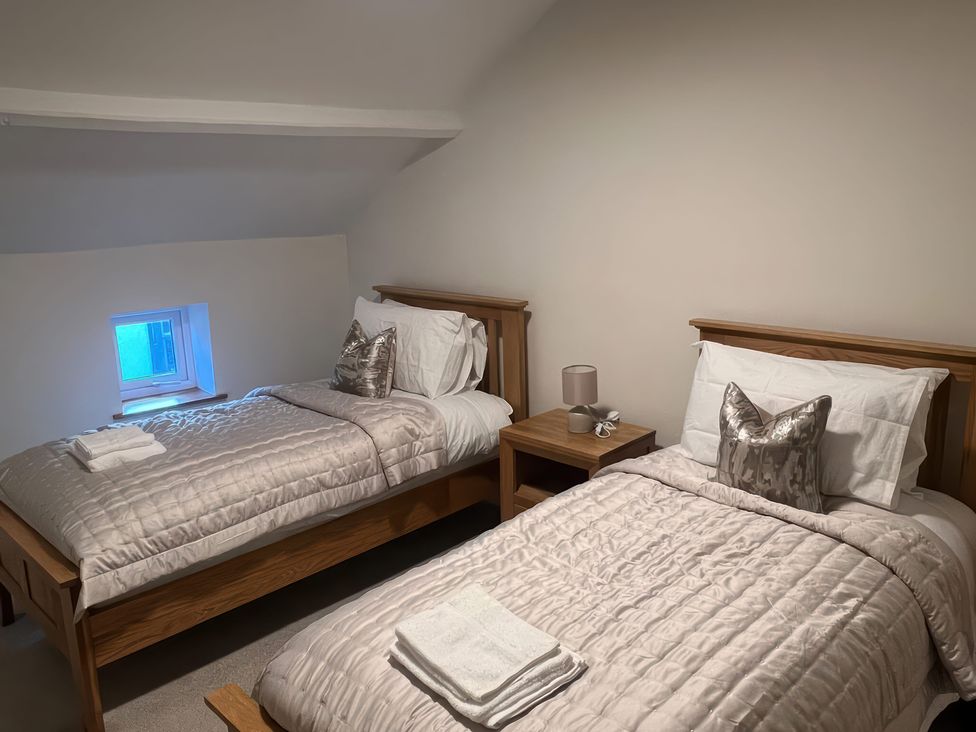 A bedroom with two beds and a window at Sun House in Allonby