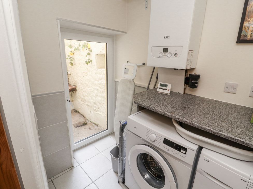 A laundry room with a washing machine and a boiler at Sun House in Allonby