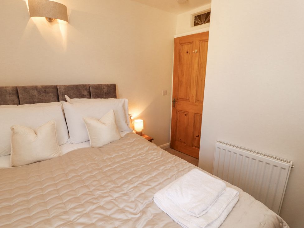 A bedroom with a bed and door at Sun House in Allonby