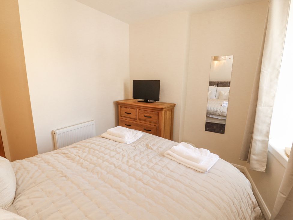 A bedroom with a bed and television at Sun House in Allonby