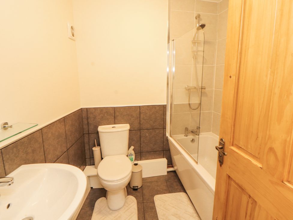 A bathroom with a toilet, sink, and bathtub at Sun House in Allonby