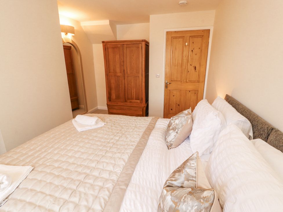 A bedroom with a bed and wardrobe at Sun House in Allonby