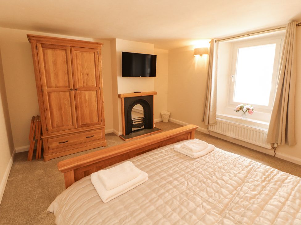 A bedroom with bed and wardrobe at Sun House in Allonby