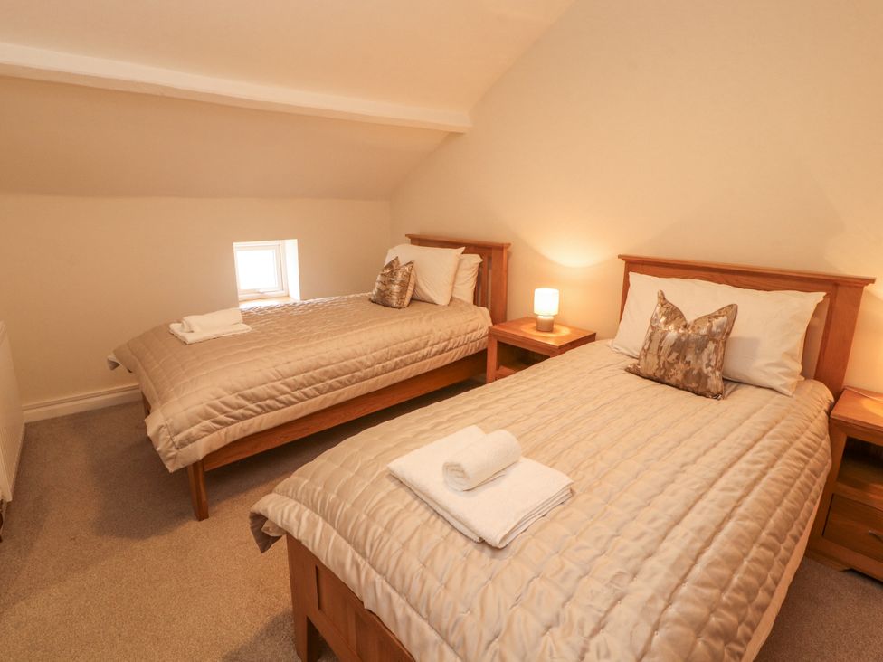 A bedroom with two beds and a window at Sun House in Allonby
