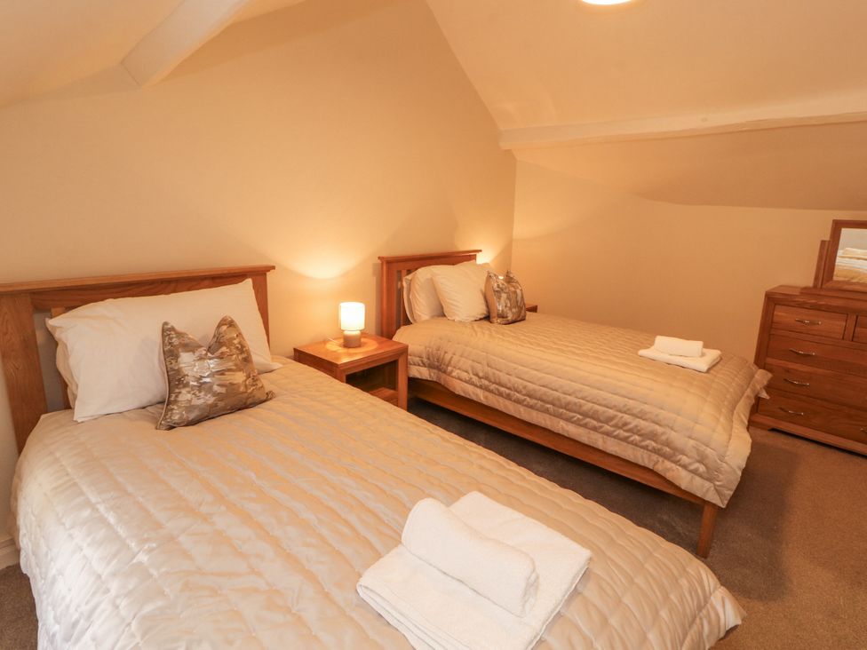 A bedroom with two beds and a dresser at Sun House in Allonby