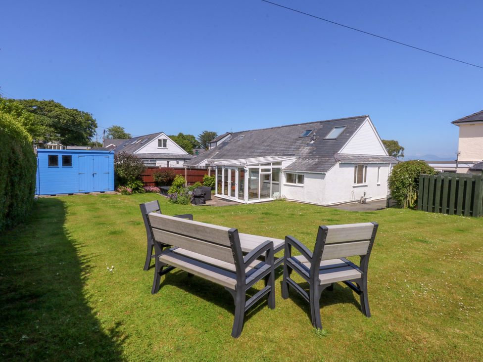 A garden with a patio set and a shed at Swn Y Don