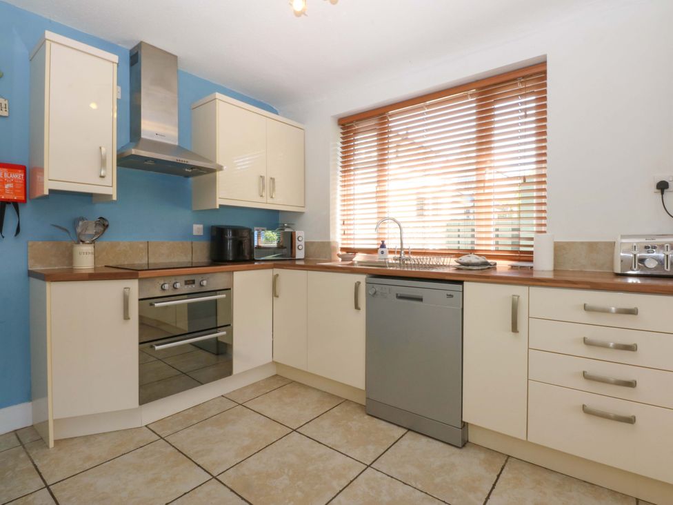 A kitchen with appliances and cabinets at Swn Y Don