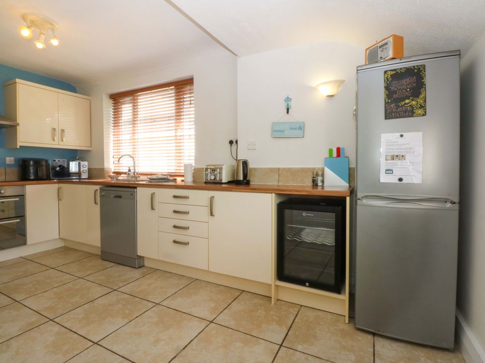 A kitchen with cabinets and appliances at Swn Y Don in 