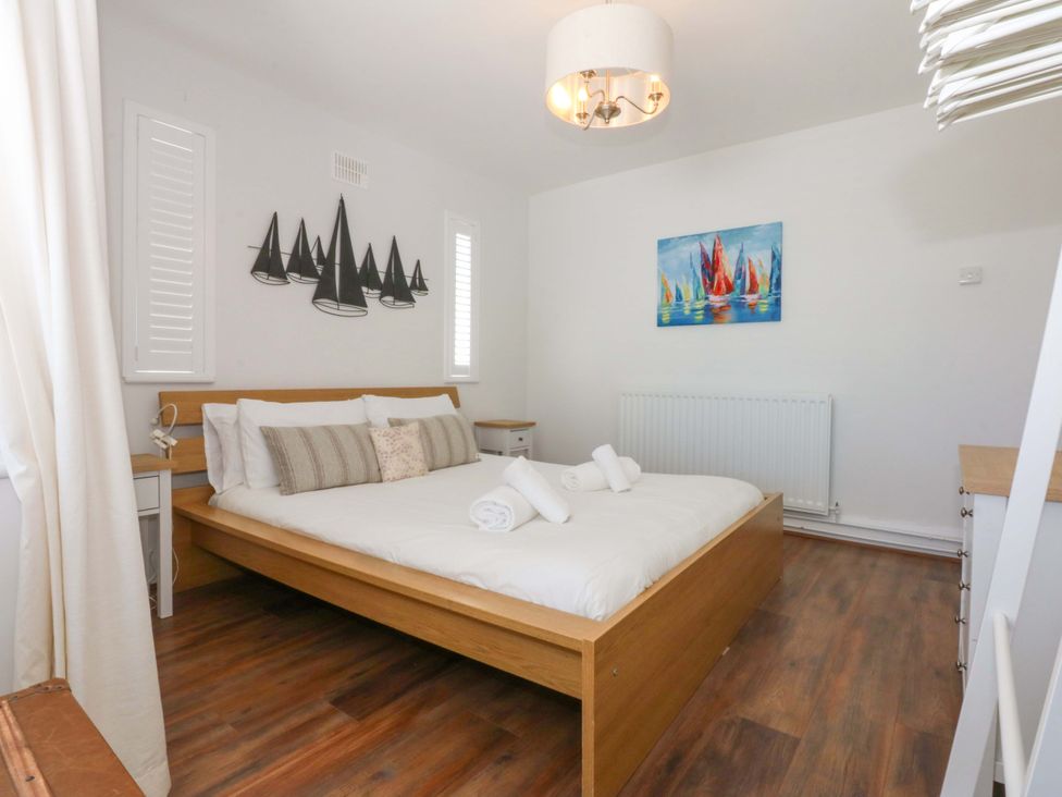 A bedroom with a bed and wall art at Swn Y Don