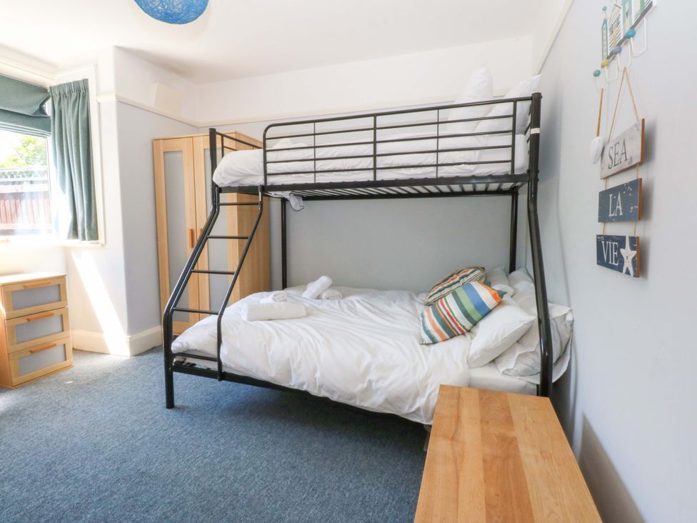 A bedroom with a bunk bed and a wooden drawer unit at Swn Y Don