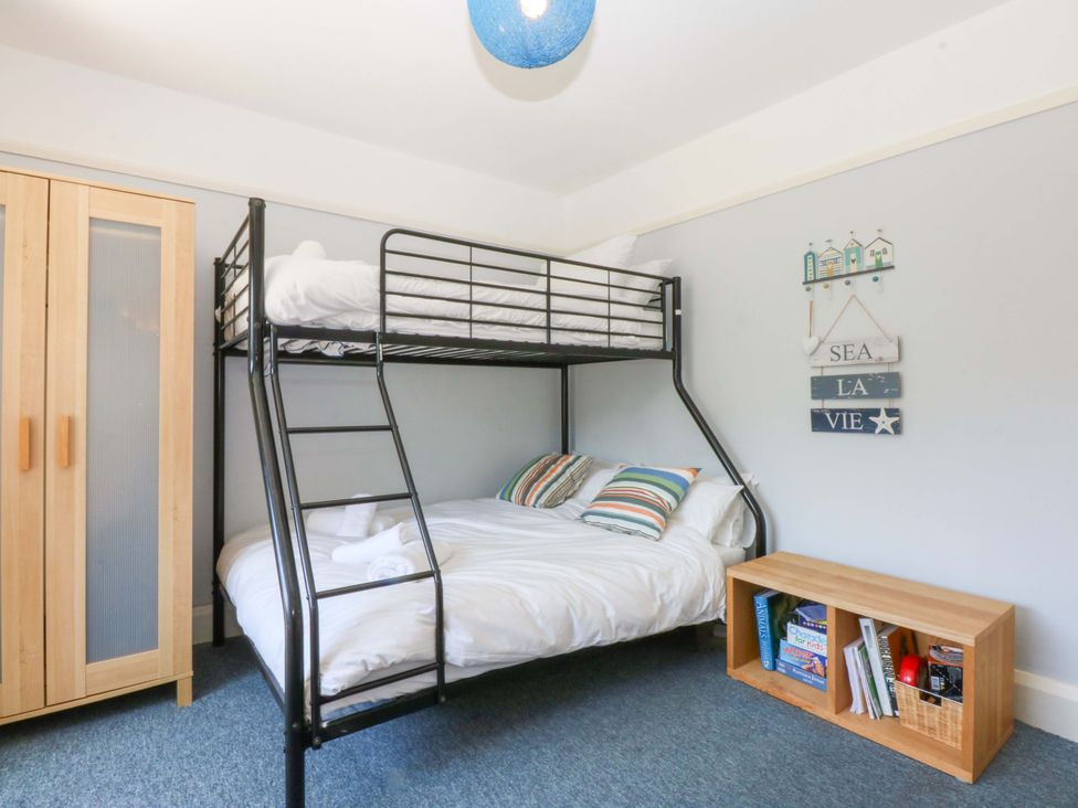 A bunk bed and a double bed with a wardrobe and bookshelf at Swn Y Don