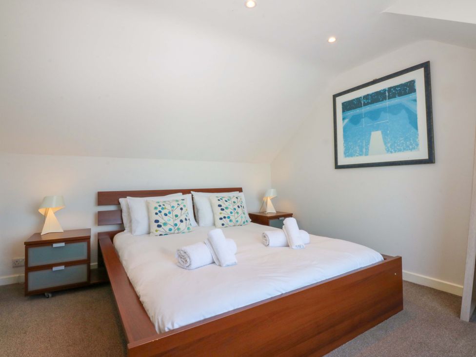A bedroom with a double bed and bedside table at Swn Y Don