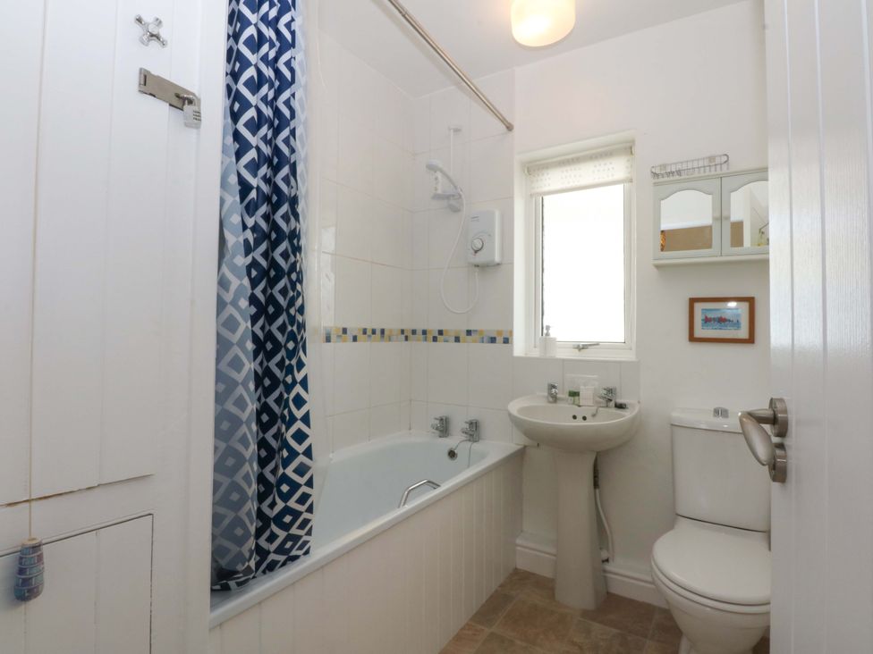 A bathroom with a bathtub, shower, sink, and toilet at Swn Y Don