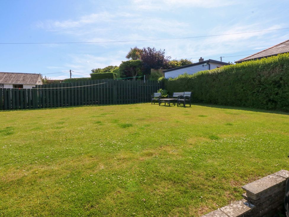 A garden with grass and seating area at Swn Y Don in 