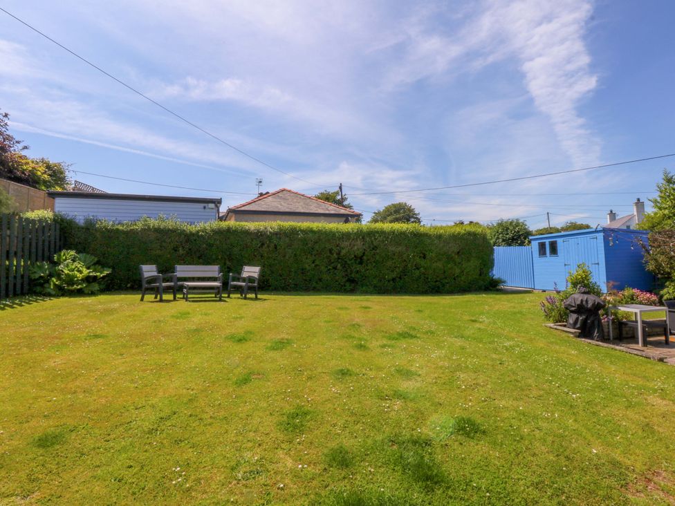 A garden with seating and a blue shed at Swn Y Don in 