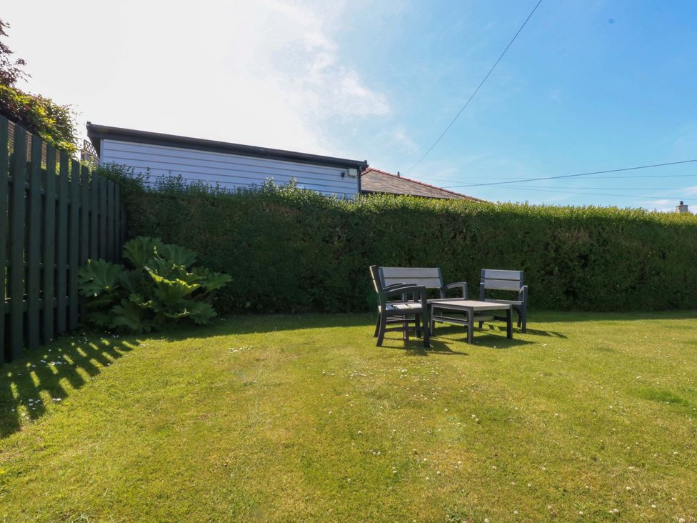 A garden with chairs and a table at Swn Y Don