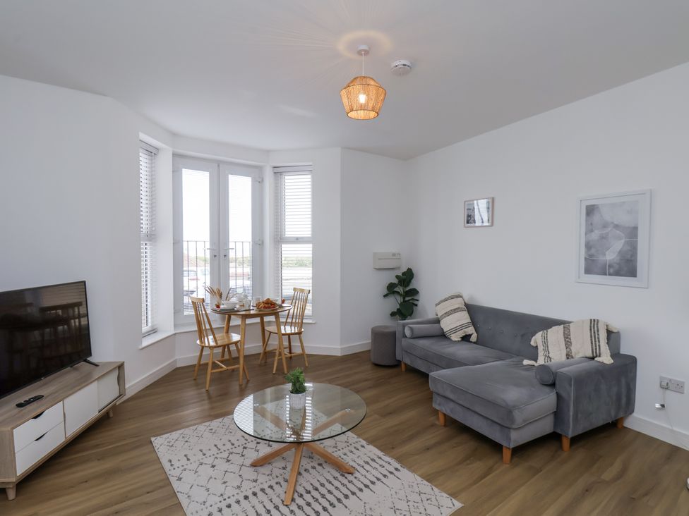 A living room with a sofa and dining area at Apartment 2 in Redcar