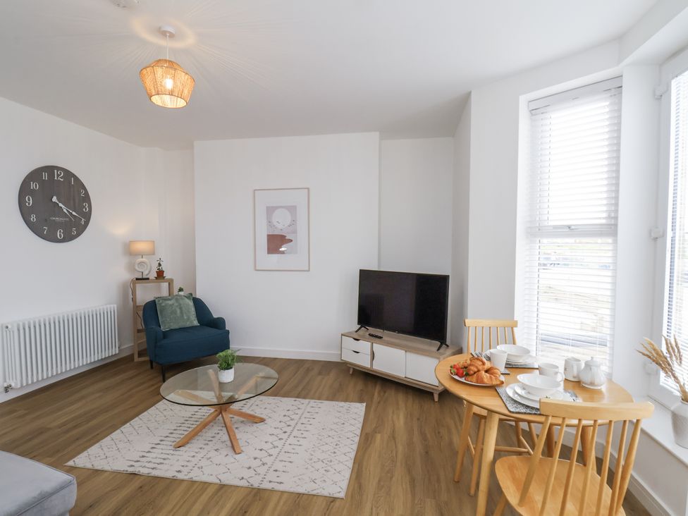 A living room with a television and table set at Apartment 2 in Redcar