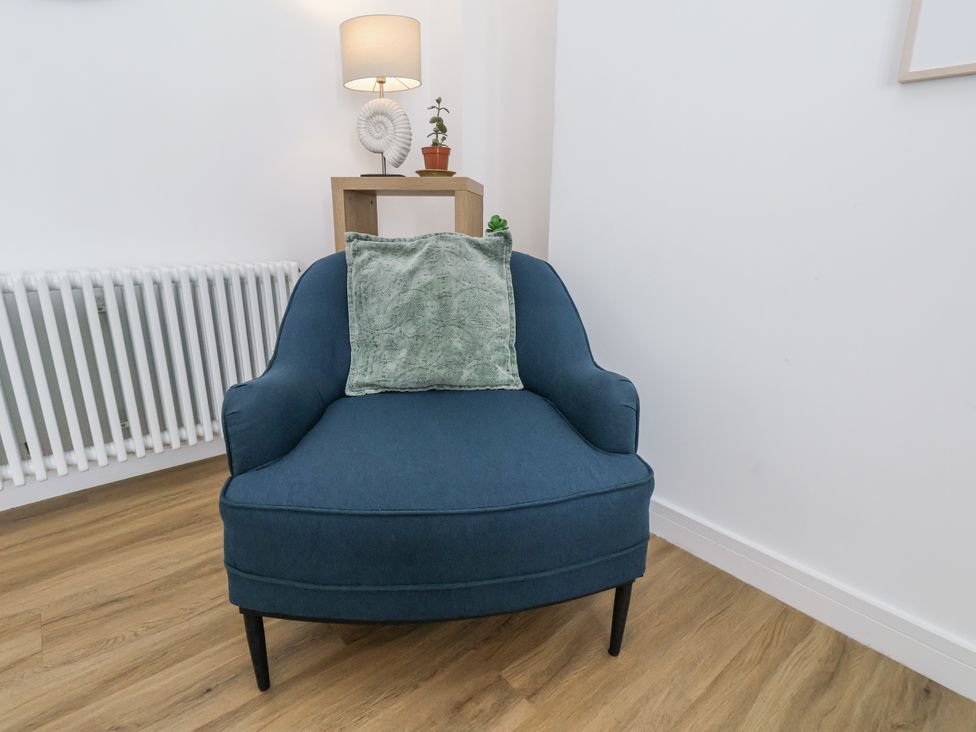 A chair with a pillow in a living room at Apartment 2 Redcar