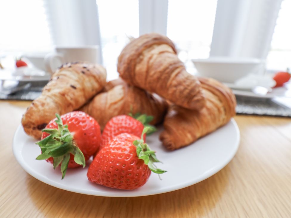 A plate with croissants and strawberries at Apartment 2 in Redcar