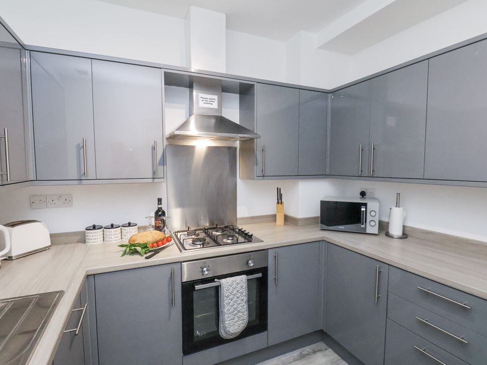 A kitchen with cabinets and appliances at Apartment 2 Redcar