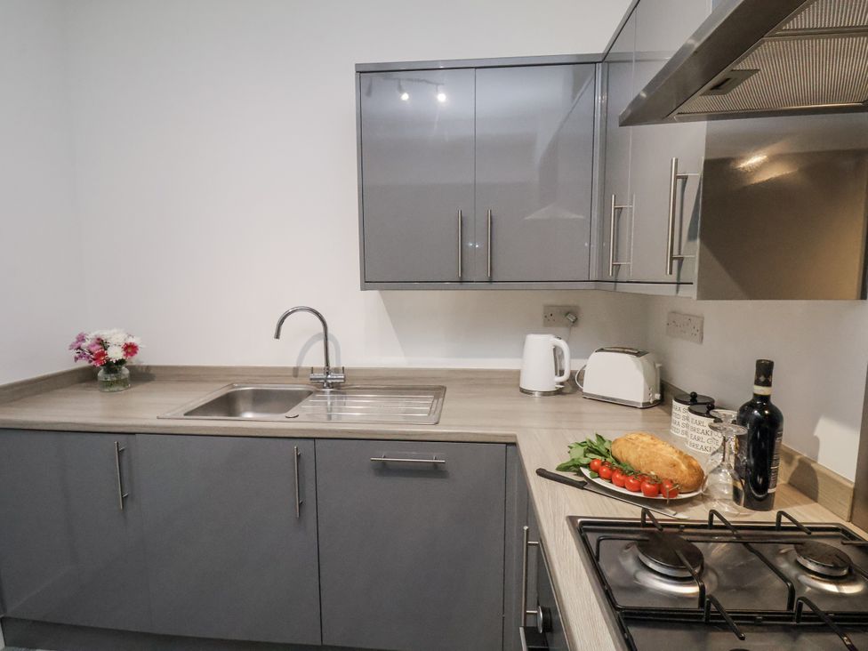 A kitchen with cabinets, sink, and stove at Apartment 2 in Redcar