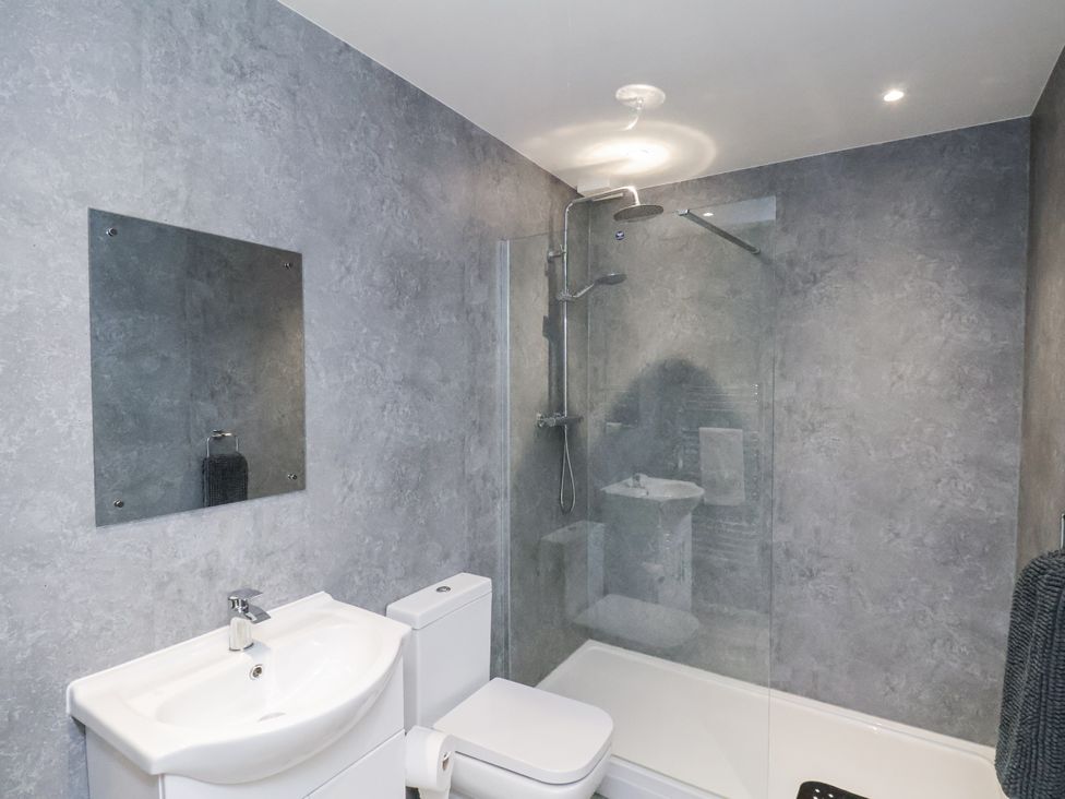 A bathroom with a sink, toilet, and shower at Apartment 2 in Redcar