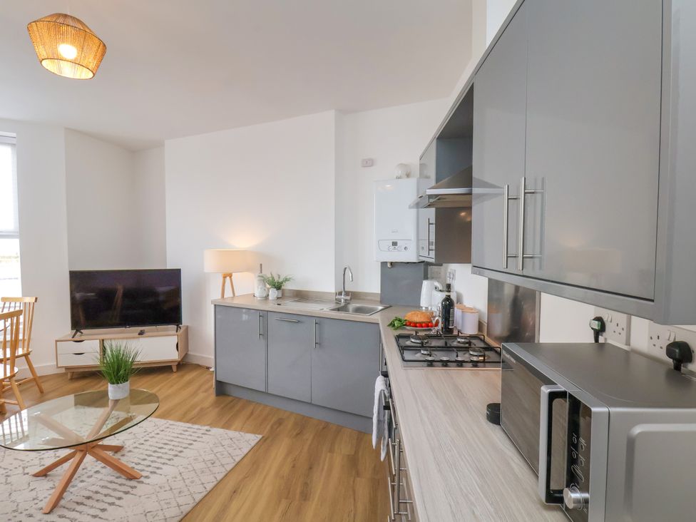 A kitchen with grey cabinets and appliances at Apartment 1 (2 bed) Redcar