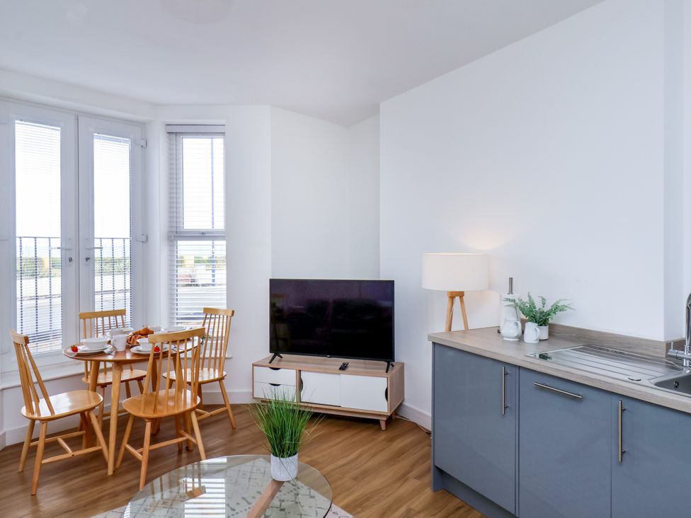 A living room with a dining table and tv at Apartment 1 (2 bed) Redcar