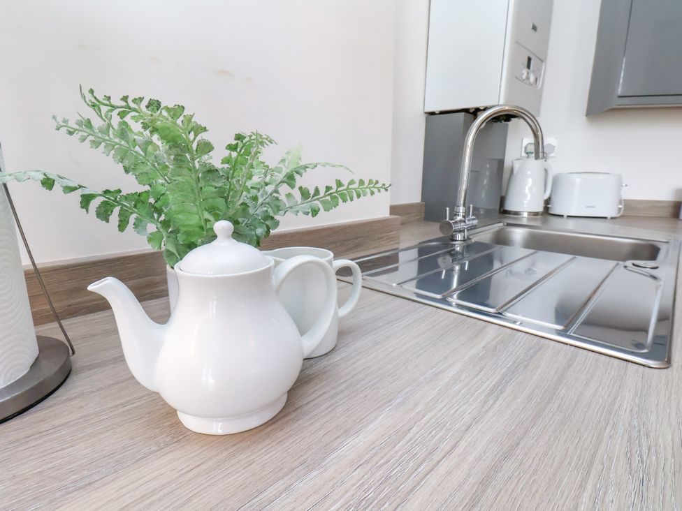 A kitchen with a teapot and cup beside a plant and sink at Apartment 1 ( 2 bed ) Redcar