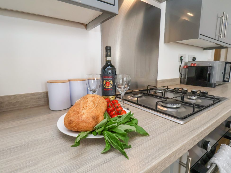 A kitchen with a loaf of bread, wine bottle, and tomatoes at Apartment 1 (2 bed) Redcar