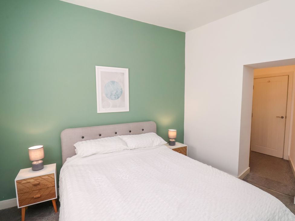 A bedroom with a bed and bedside tables at Apartment 1 ( 2 bed ) Redcar